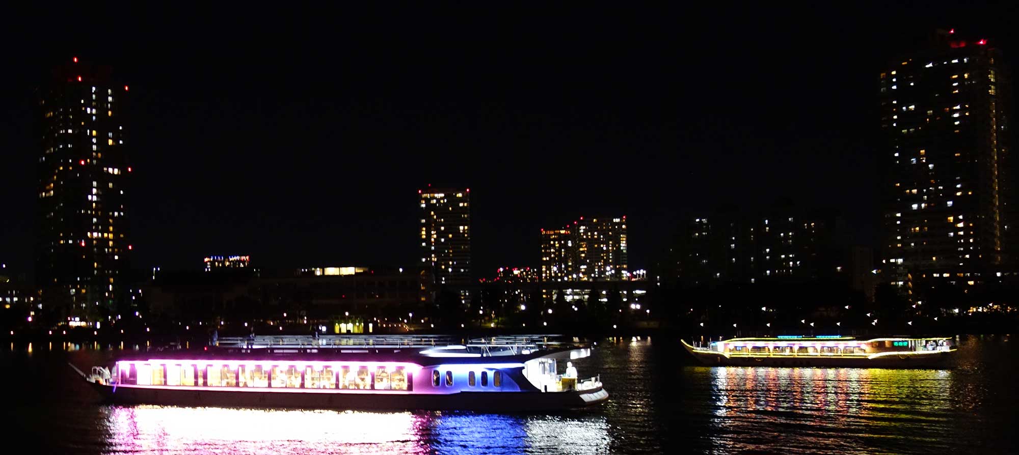 Традиционное судно-ресторанчик ятака-бунэ в Токийском заливе на фоне ночного города